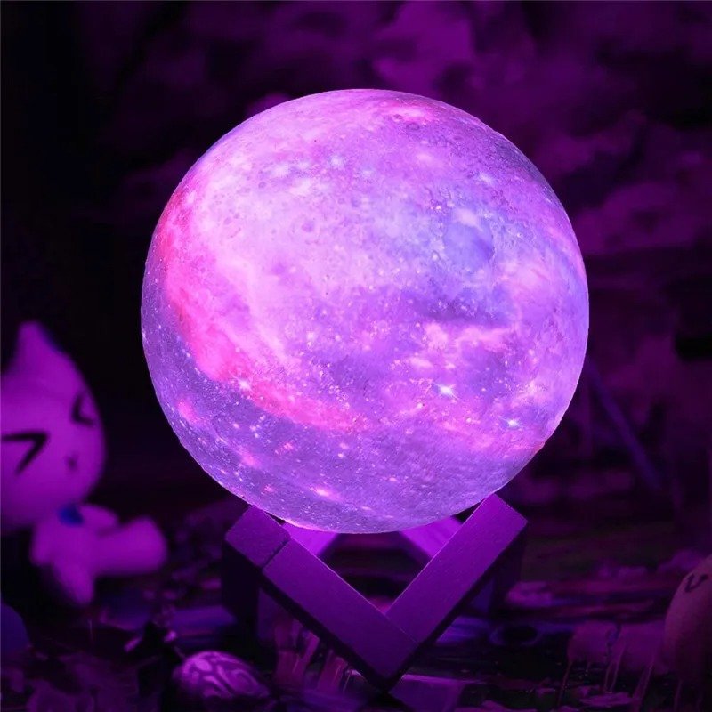 Lampe sphérique galaxie violette posée sur un support angulaire sombre, avec un décor flou aux teintes violettes et un personnage de chat stylisé en arrière-plan.